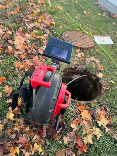Sewer camera reel set up at an open cleanout for a sewer line inspection.