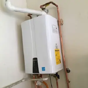 Tankless water heater installed with copper water piping and a gas line.