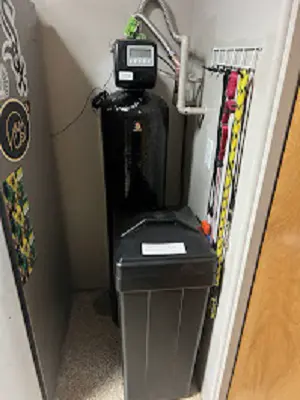 Water softener installed in a garage corner.