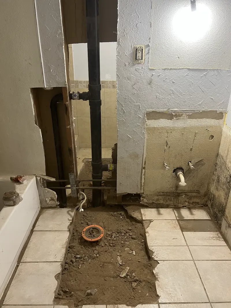 Bathroom floor trenched open to reach the drain lines under the slab.