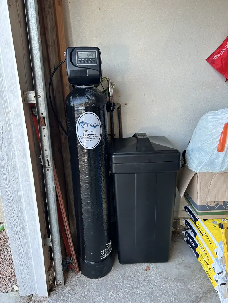 Water softener with a Fleck control valve installed in a garage.
