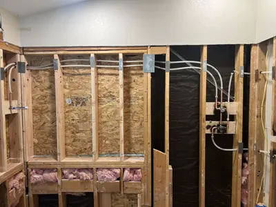Opened walls showing new PEX piping during a whole-home repipe.