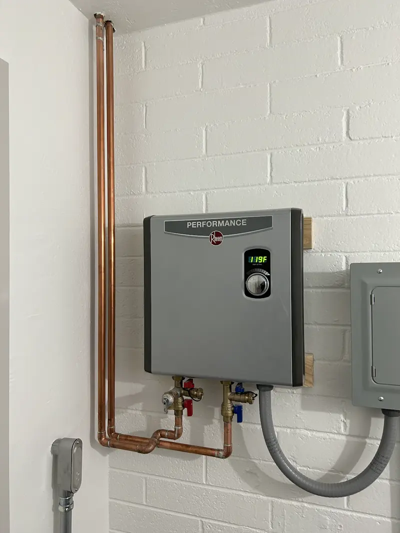 Rheem electric tankless water heater installed with copper piping.