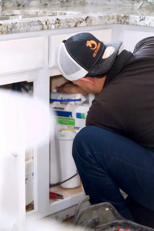 Technician installing an under-sink water filter.