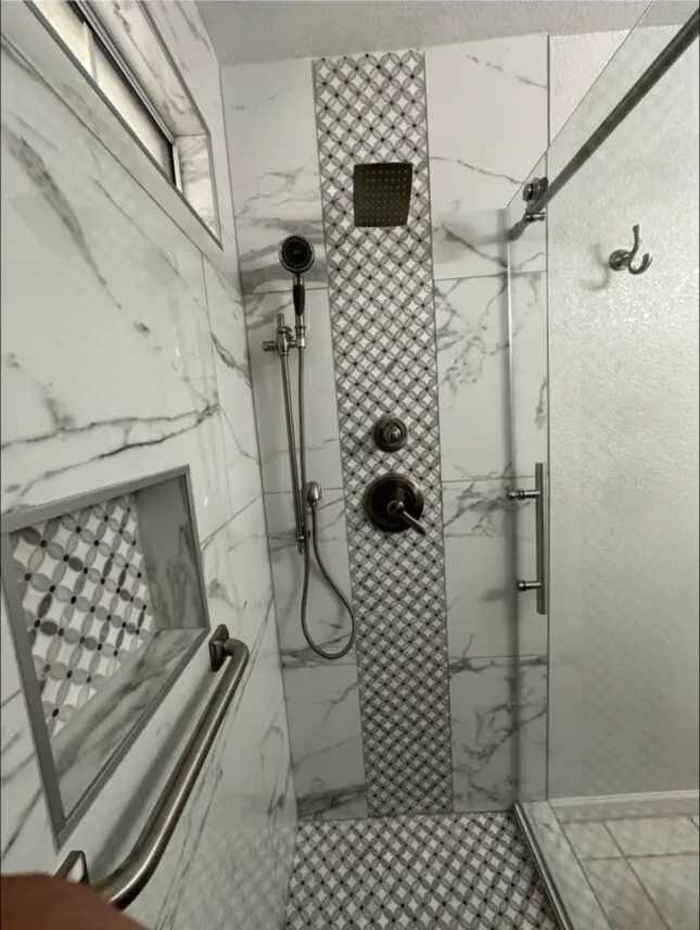 Shower remodel with a mosaic tile stripe and a built-in niche.