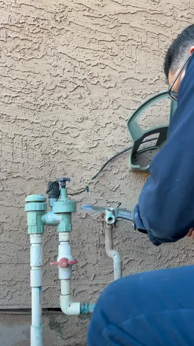 Technician working at an irrigation backflow preventer.