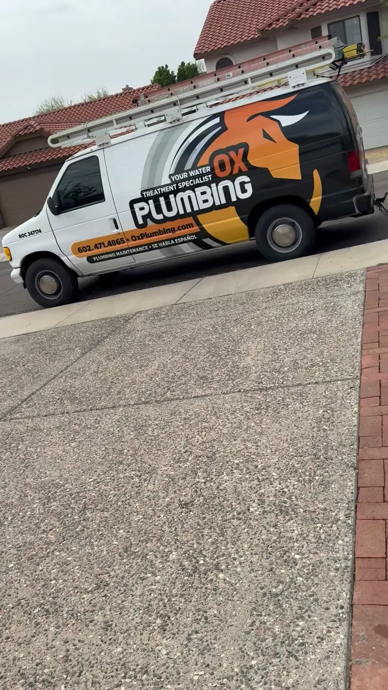 OX Plumbing van parked at a curb.
