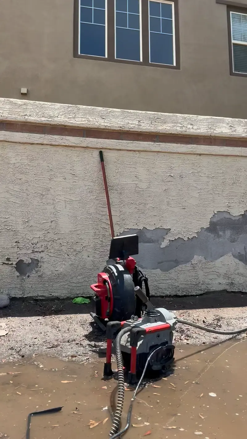 Drain cleaning machine running at an outdoor cleanout.